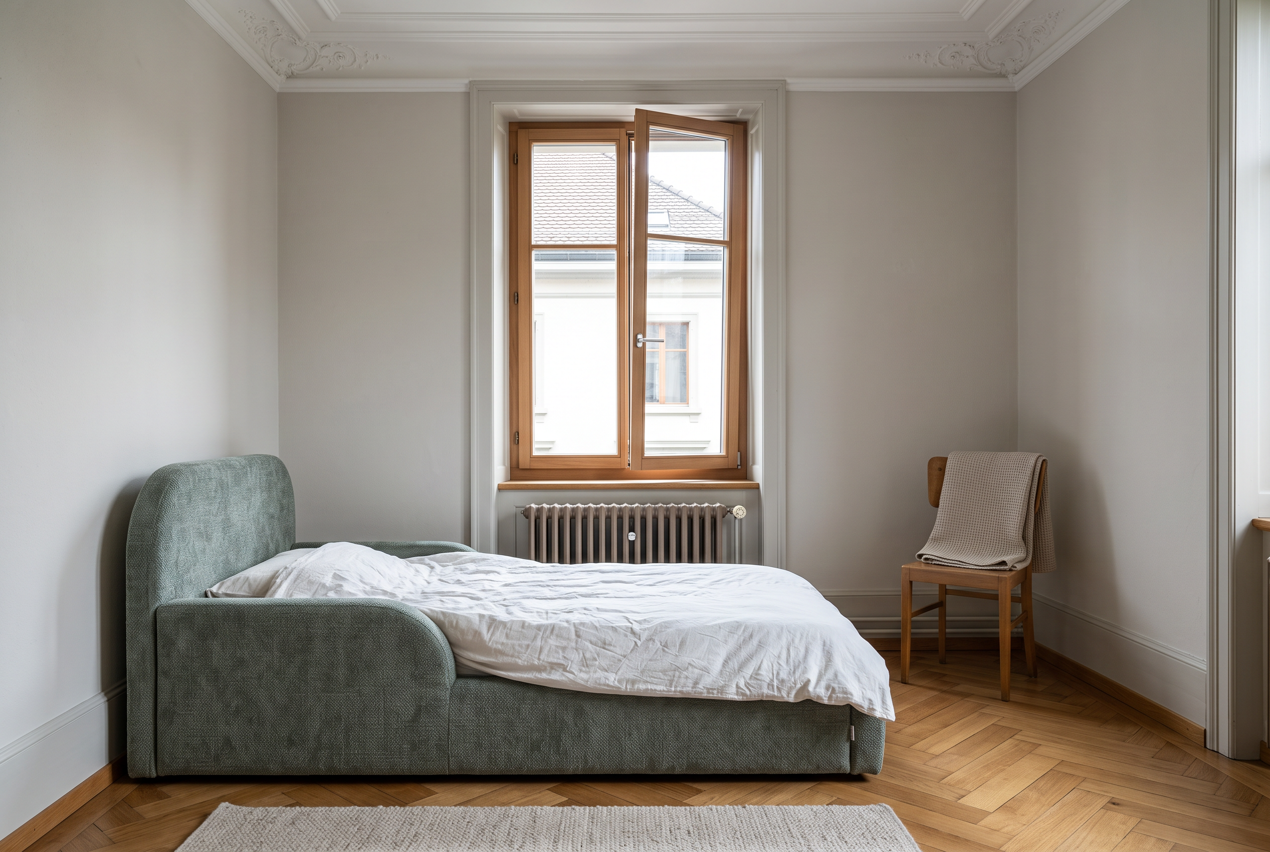 Kinderzimmer im Altbau mit gekipptem Fenster, Heizkörper und niedrigem gepolstertem Kinderbett